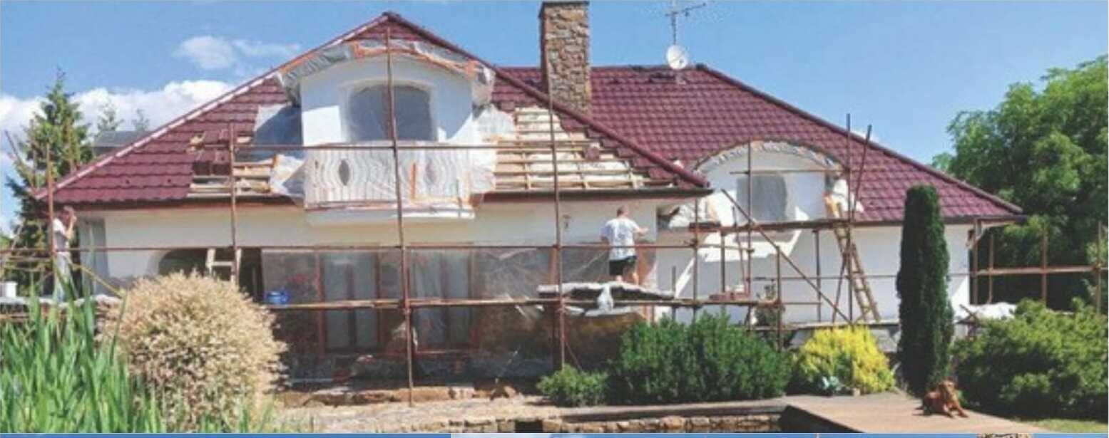 Eingerüstetes Haus mit rotem Dach während der Sanierungsarbeiten